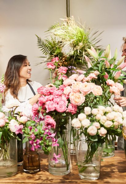 Zwei Floristen binden gemeinsam einen Blumenstrauß im Blumenladen